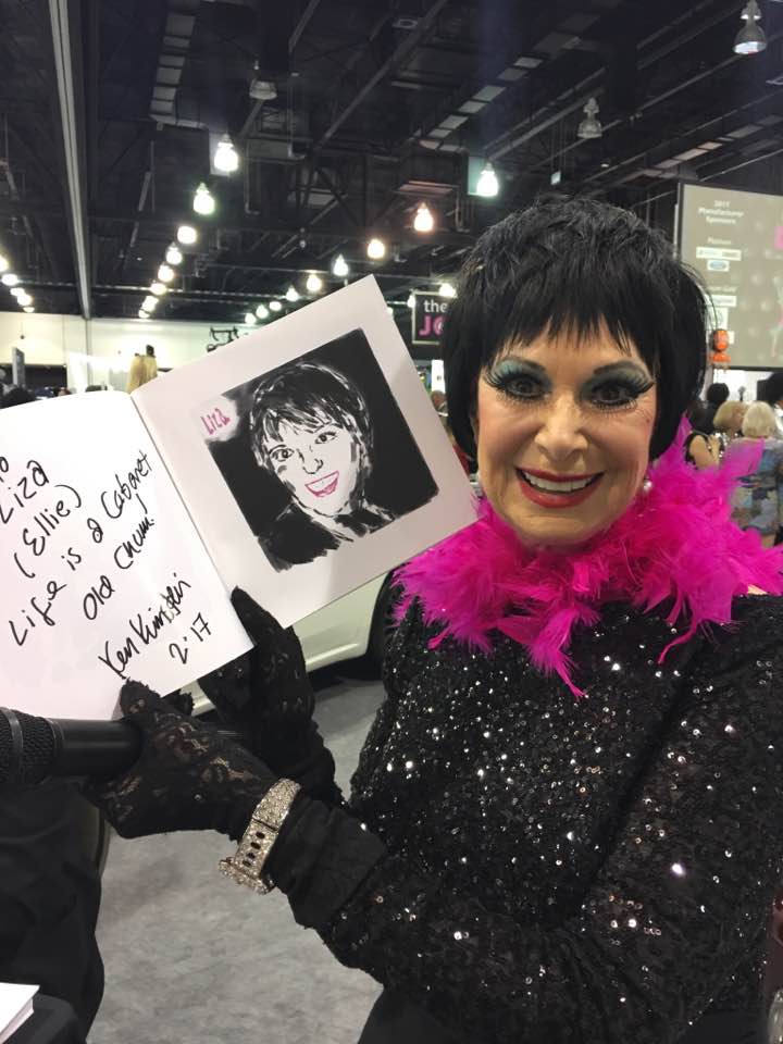 A woman holding up a sign with a picture of herself.